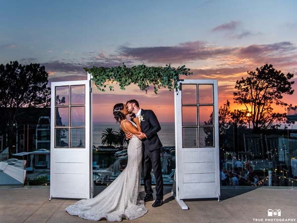 Bride and groom kissing under the sunset.